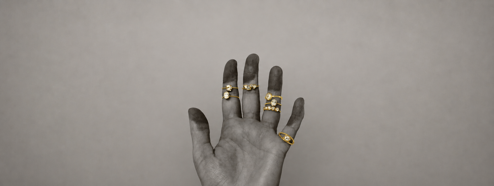 Main avec diverses bagues or jaune et diamants de synthèse